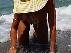 Madura con piercings en los pezones estirados y múltiples piercing en la playa