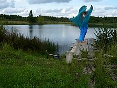 En bikini-kvinne danser ved innsjøen