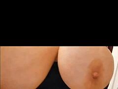 Zrelá žena s veľkými prirodzenými prsiami sa vyzlieka a predvádza svoje telo
